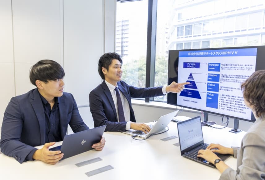 社内で会議を行う3名の社員