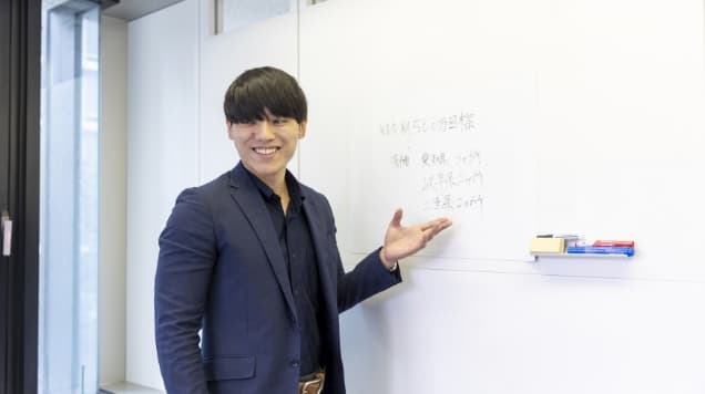 ホワイトボードを用いて説明する社員