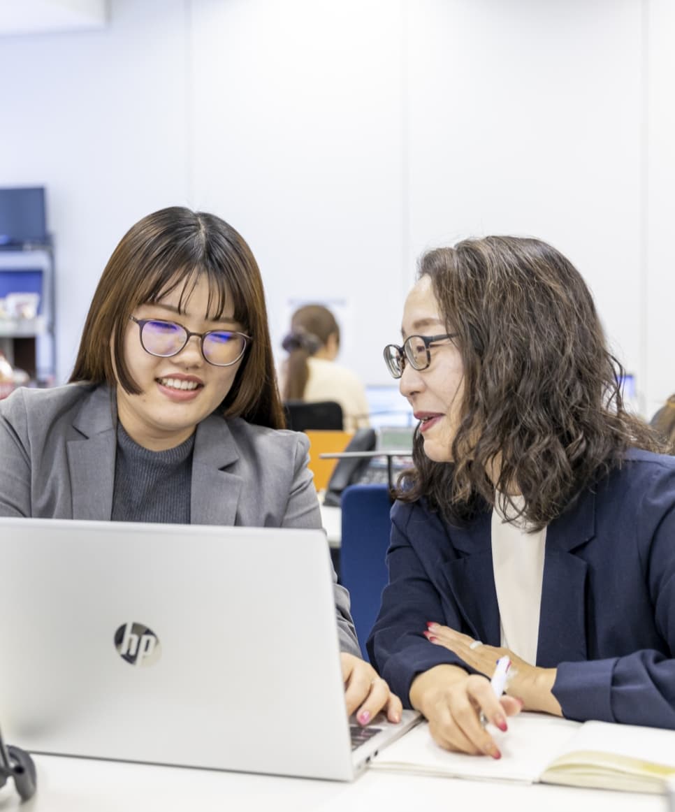 社内で笑顔でやり取りをするアシスタント