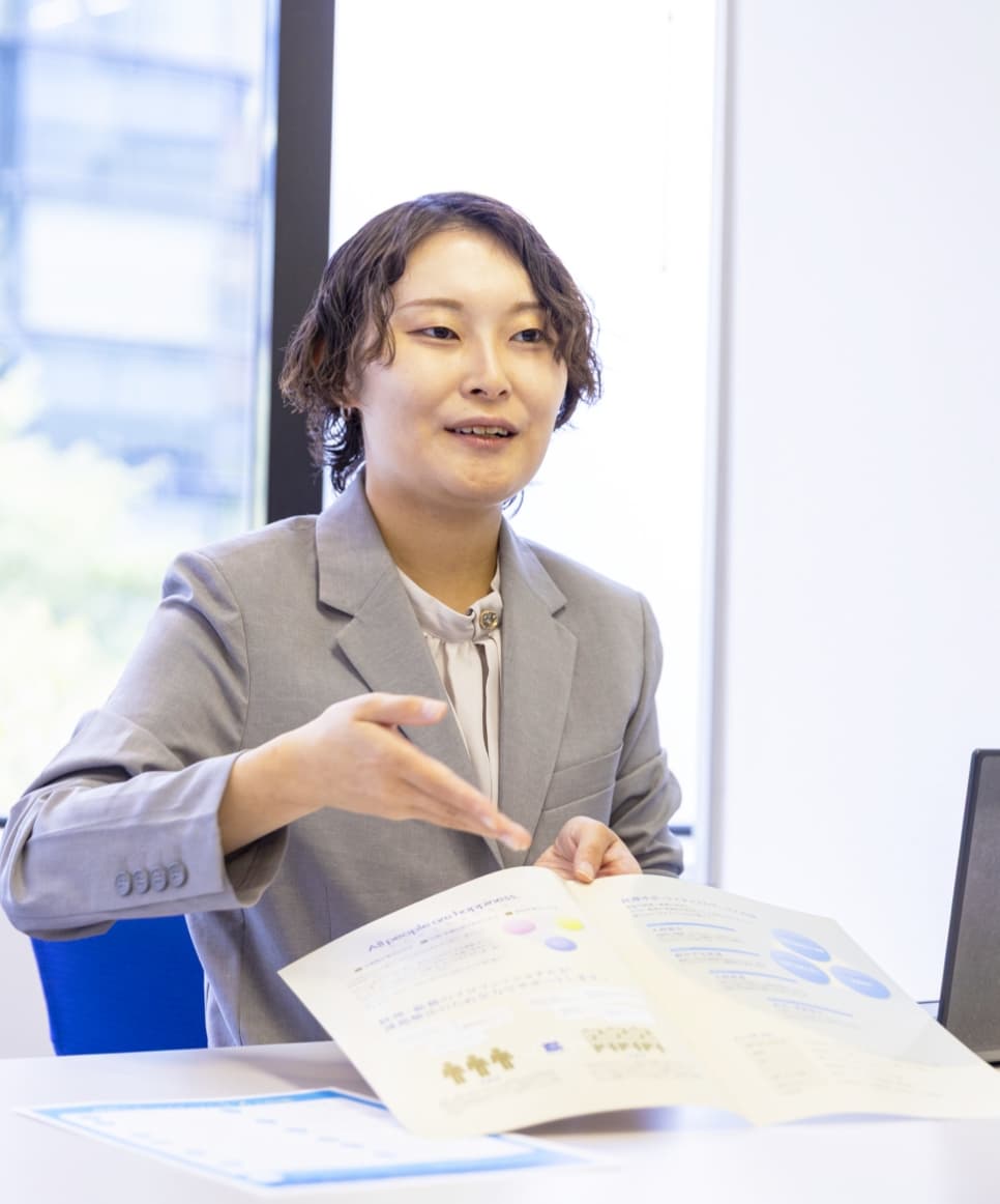 資料を用いてクライアントに説明するコンサルタント